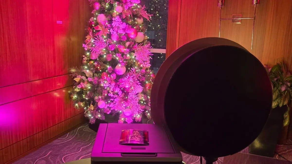 Borne photo et imprimante Ouisnap devant un sapin illuminé lors d'un party de Noël d'entreprise